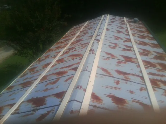 Rusted metal roof panels with new wood purlins before replacement — Storm Damage Roof Repair in Truro by Roofing Brothers